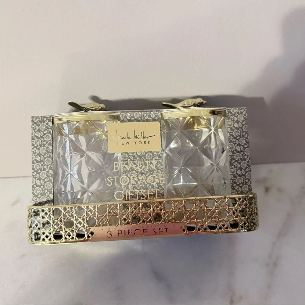 two-piece glass storage jar set with a gold bird lid and decorative tray.